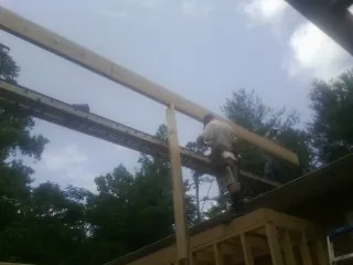 Carpenter setting a ridge beam over a new addition frame — Ice Dam Removal by Roofing Brothers in New Glarus
