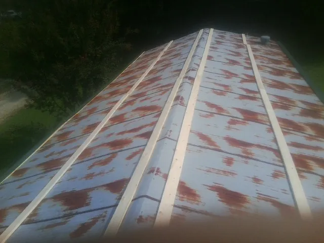Rusted metal roof panels with new wood purlins before replacement — Storm Damage Roof Repair in New Glarus by Roofing Brothers