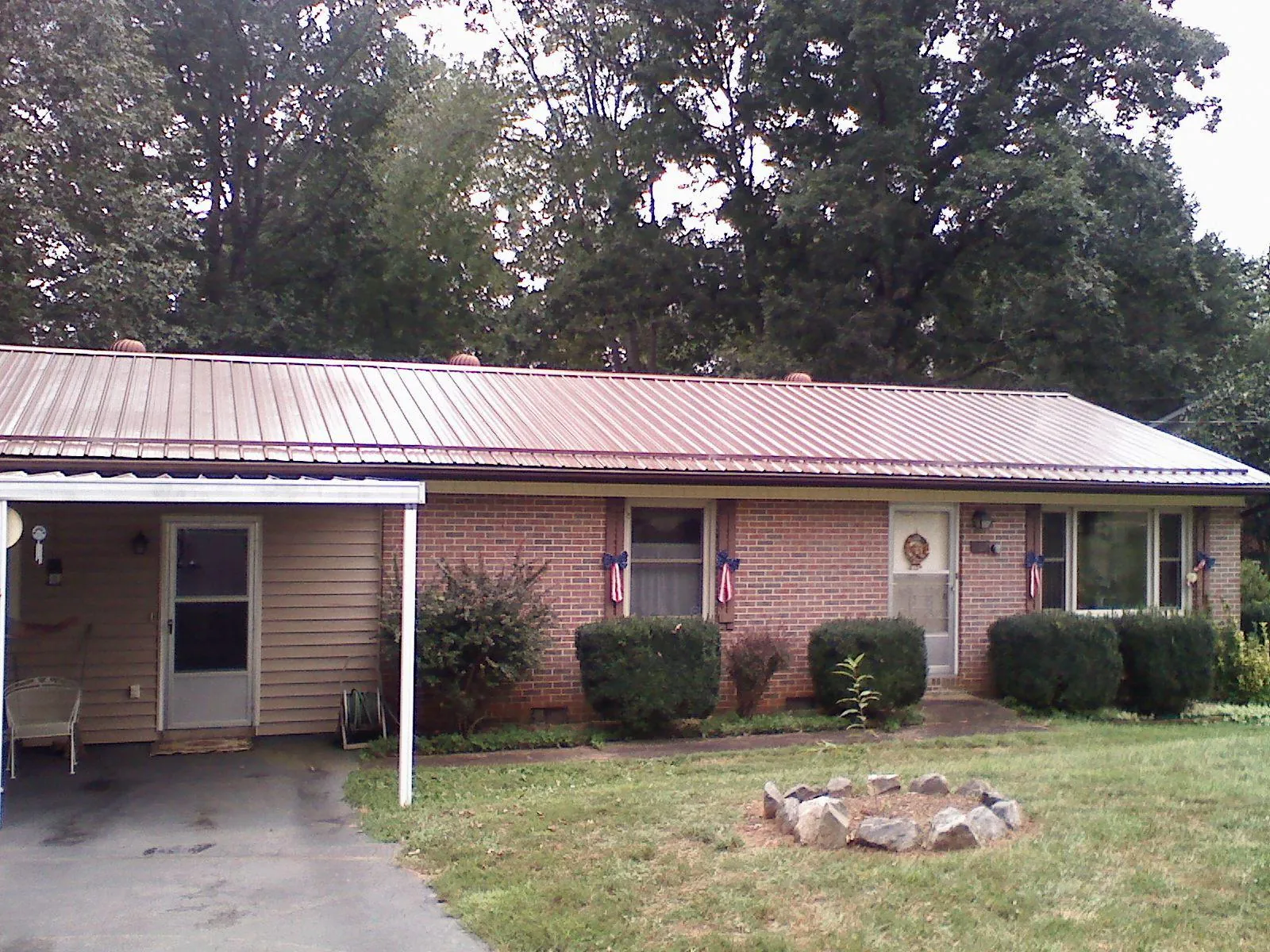 Bronze metal roof and carport on a brick ranch home — Roof Repair work by our crew in New Glarus