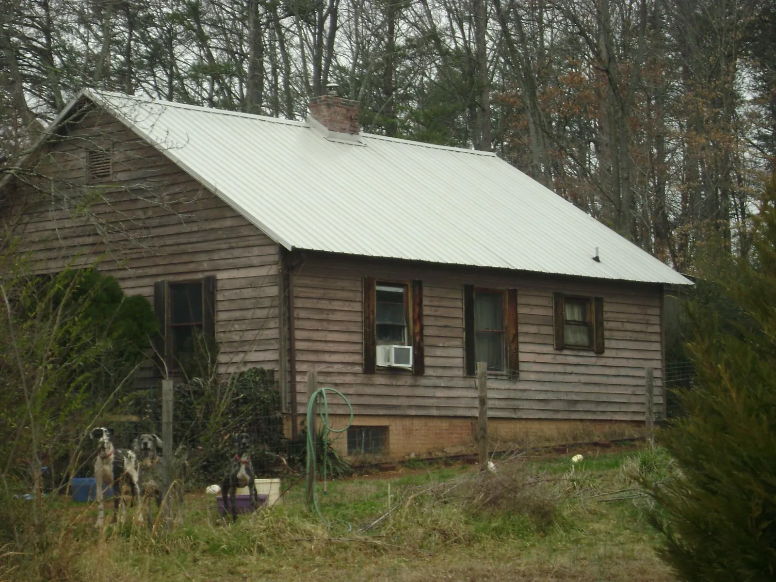 White metal roof on an old wood sided farmhouse, from a Metal Roof Installation job in New Glarus